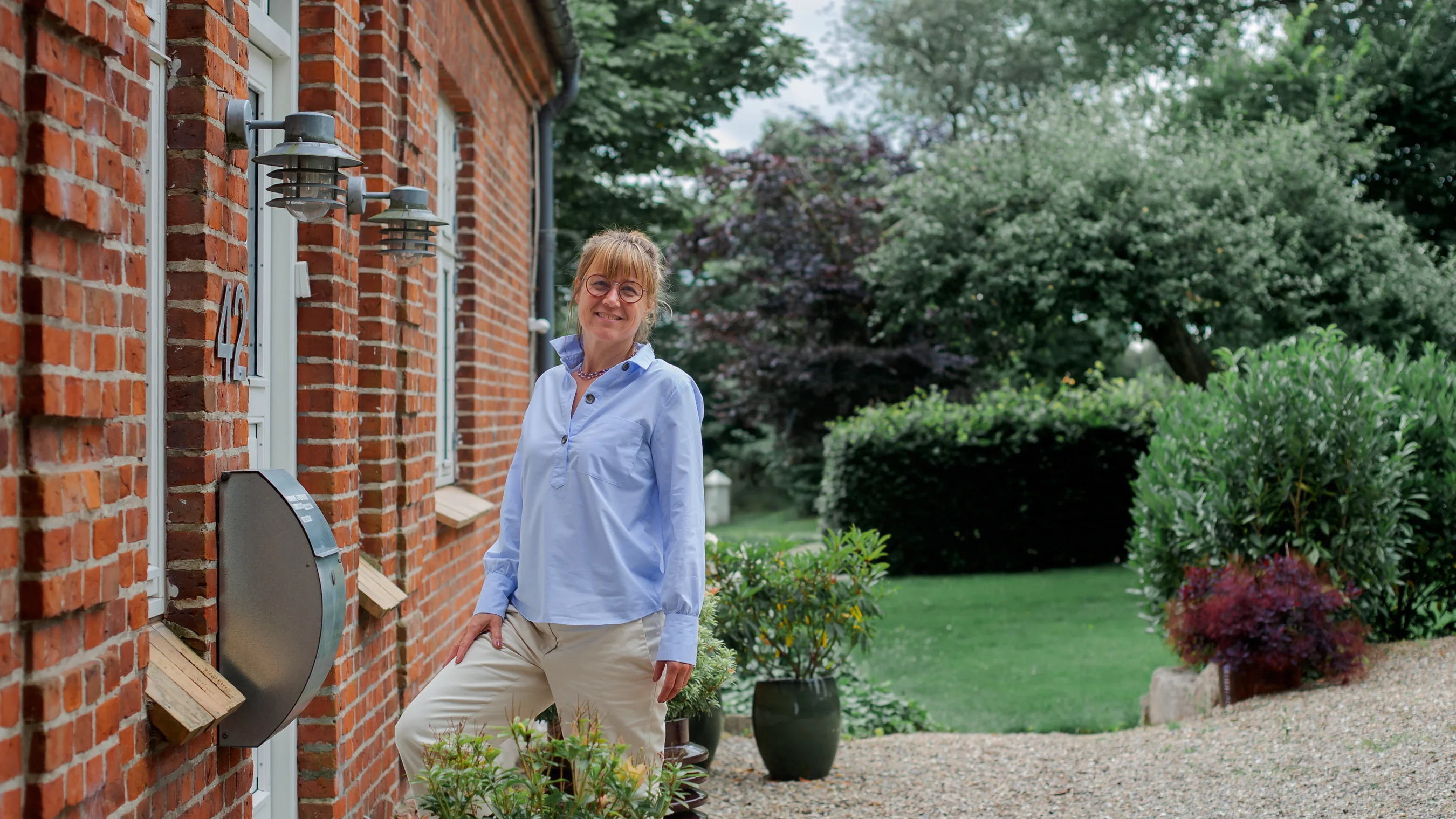 Therapist in from of her green garden